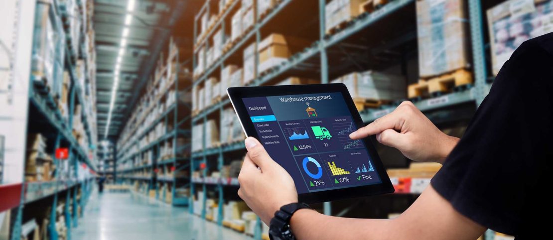 man walking through warehouse with an iPad showing warehouse management software