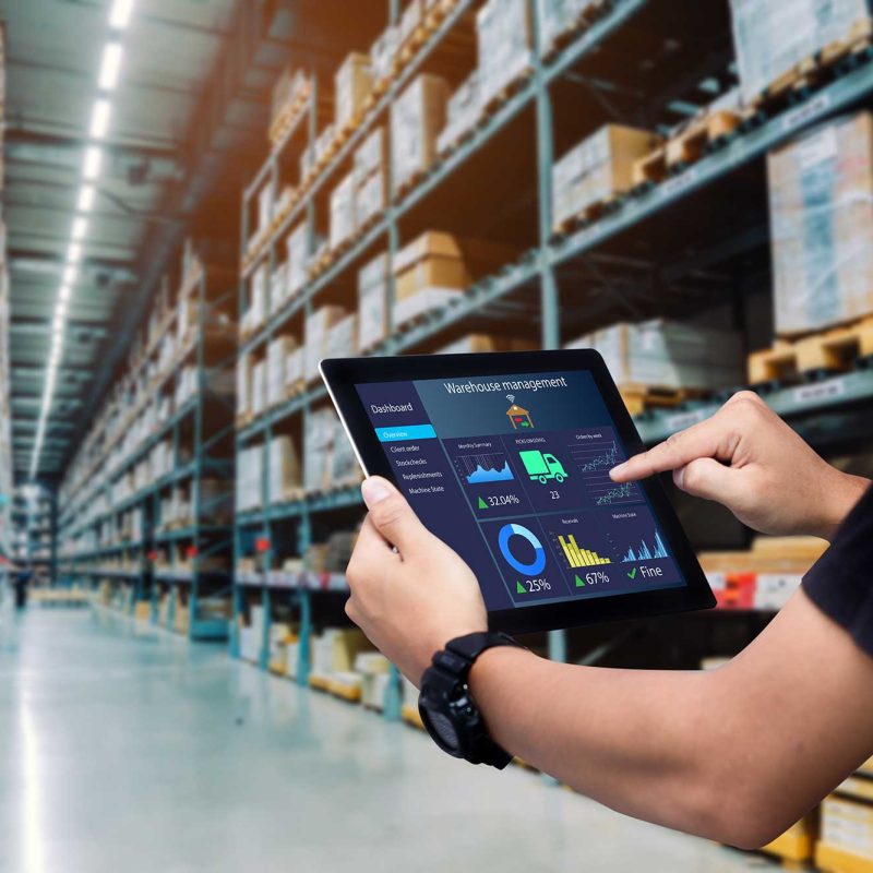 man walking through warehouse with an iPad showing warehouse management software